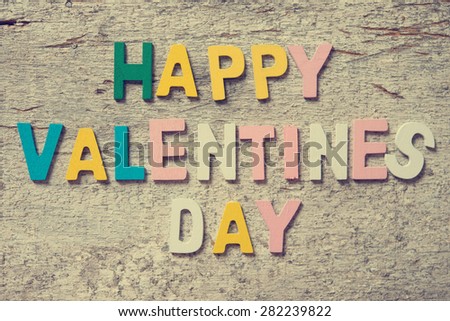 The colorful words "HAPPY VALENTINES DAY" made with wooden letters on old wooden board.