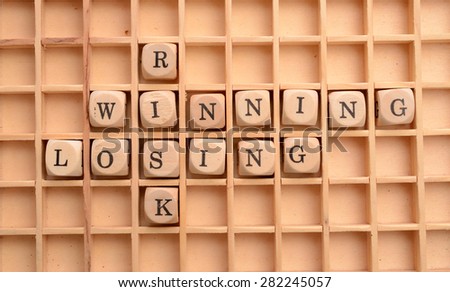 Business concept with wooden dices and the words Risk, winning and losing