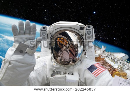 Astronaut on space mission with earth on the background.
Elements of this image furnished by NASA.