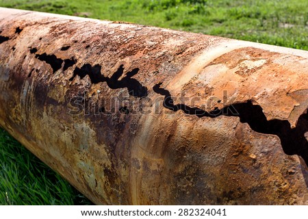 Fragments of old large water pipes. After many years of operation, corroded metal pipe destroyed. Rusty steel tube with holes metal corrosion. Selective focus. Royalty-Free Stock Photo #282324041