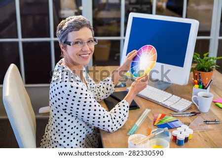 Casual businesswoman holding colour chart in the office