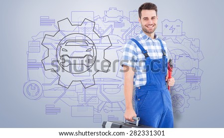 Smiling young male repairman carrying toolbox against grey vignette