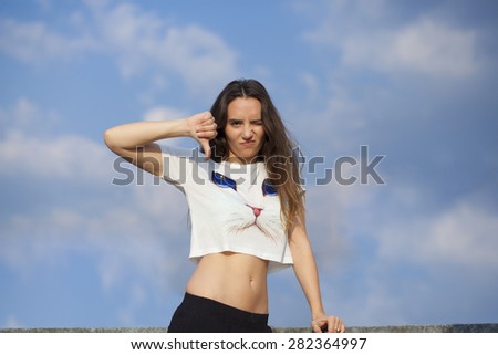 Beautiful young woman showing thumb down