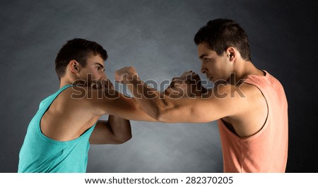 sport, competition, strength and people concept - young men wrestling