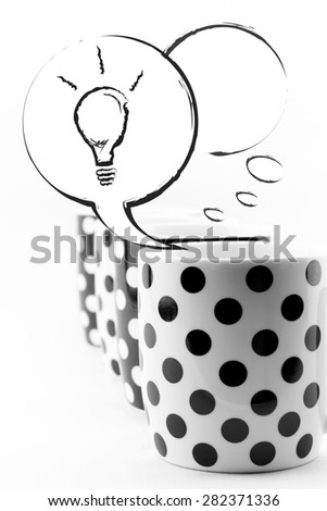 Coffee mugs with speech bubbles and light bulb isolated on white