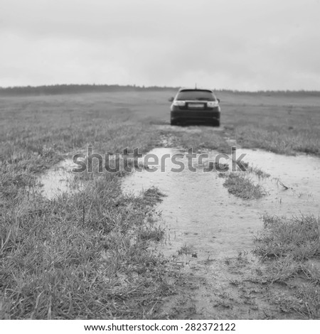 Car stuck in a puddle, outdoor shot, focus in the foreground in black and white