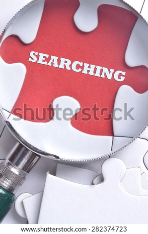 Magnifying glass searching the word "SEARCHING" on the puzzle