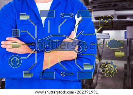 Male mechanic holding spanner on white background against auto repair shop