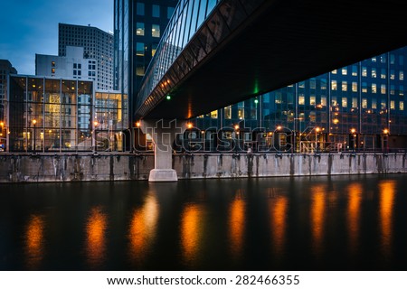 Buildings and pedestrian bridge over the Milwaukee River at night, in Milwaukee, Wisconsin.