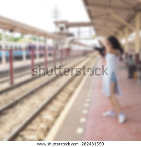  Blurred woman using a camera on the station.