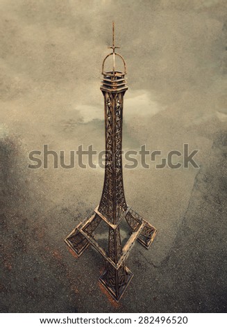 The Eiffel Tower in miniature on a brown background.