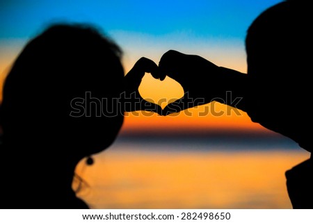 The couple silhouettes in twilight  hand heart , blurry