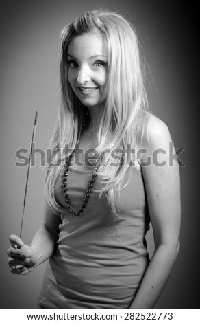 Attractive caucasian blond girl isolated on a grey background, black and white image