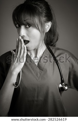 Attractive Indian doctor woman posing in a studio in front of a background, black and white image