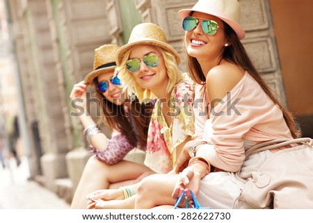 A picture of a group of happy friends resting after shopping in the city