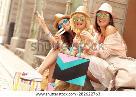 A picture of a group of happy friends resting after shopping in the city