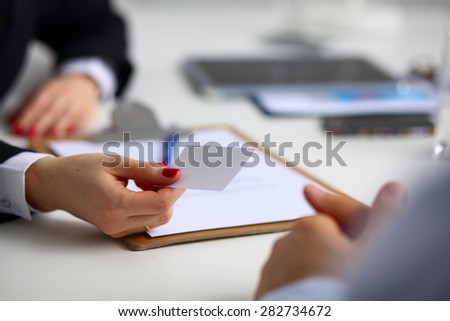 Female hand holding a blank business card .