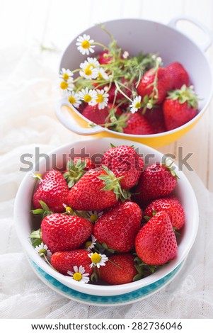 Fresh organic strawberry in bowl on  white wooden background. Selective focus. Rustic style.