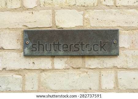 Empty stone plate mounted on brick wall closeup
