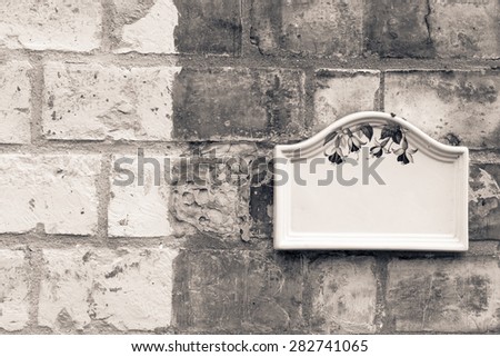 Blank plate mounted on a brick wall closeup
