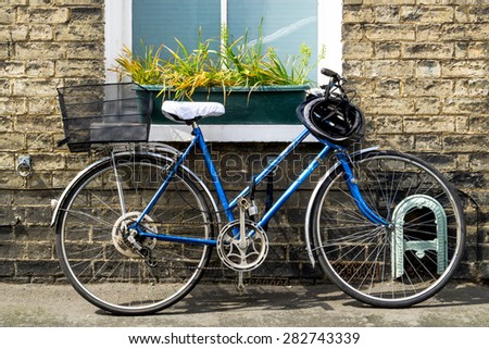 Old bicycle parked in front of a rustic cottage closeup
