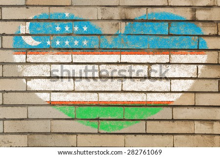 heart shaped flag in colors of uzbekistan on brick wall