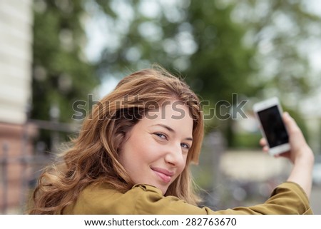 Close up Pretty Blond Girl Looking at the Camera While Holding a Mobile Phone to Take Selfie Photo.