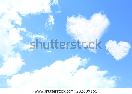 White clouds in shape of hearts on blue sky background