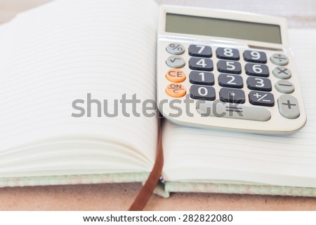 Calculator on blank notebook, stock photo