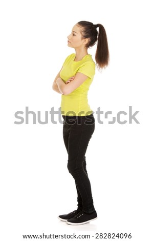 Friendly smiling young student woman with folded arms.