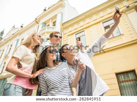 Double couple date. Friends walking down the street together and making selfie.