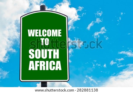 Green road sign with greeting message WELCOME TO SOUTH AFRICA isolated over clear blue sky background with available copy space. Travel destination concept  image