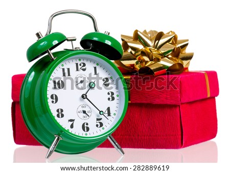 Big green alarm clock with gift box, isolated on white background