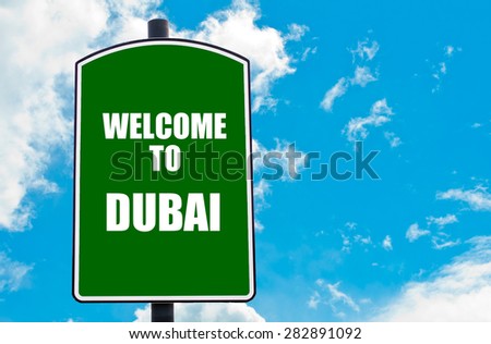Green road sign with greeting message WELCOME TO DUBAI isolated over clear blue sky background with available copy space. Travel destination concept  image