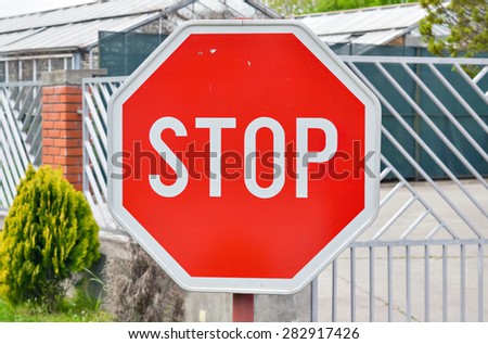 Closeup of a traffic stop sign by the road near an intersection