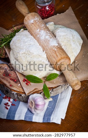 Pizza dough with ingredients on the wooden table