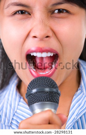 A woman is shouting and using the microphone. Shallow depth of field, focus mainly on her eyes.