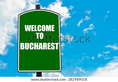 Green road sign with greeting message WELCOME TO BUCHAREST, ROMANIA isolated over clear blue sky background with available copy space. Travel destination concept  image