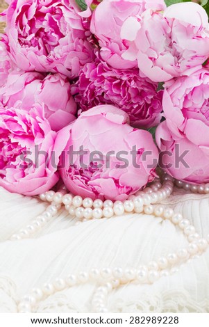 fresh pink  peonies with pearls on white lace background