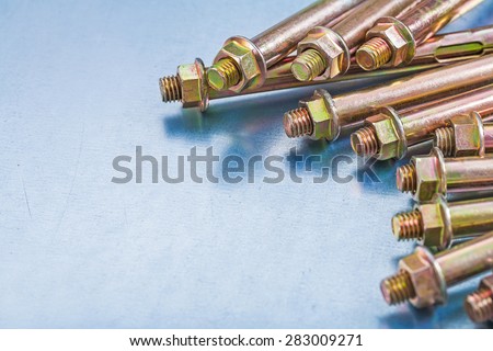 Horizontal version of anchor bolts for concrete walls and construction nuts on metallic background repairing concept 
