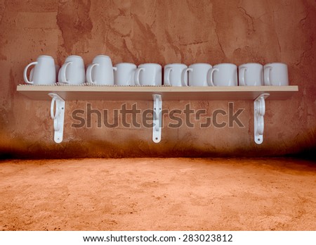 White ceramic coffee cups on the wooden shelf with grunge cement background,retro filter effect