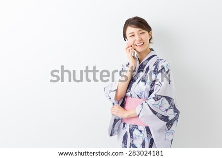 young attractive Japanese woman in a Yukata who talks on the telephone