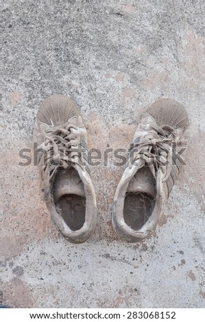 Dirty old shoes on concrete floor