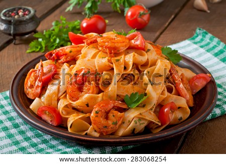 Fettuccine pasta with shrimp, tomatoes and herbs Royalty-Free Stock Photo #283068254