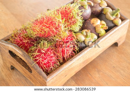 Fresh rambutan and mangosteen on wooden tray, stock photo
