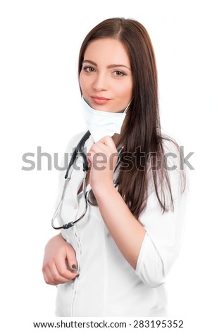  A close-up portrait of a pretty female doctor or nurse with stethoscope wearing a surgical mask  isolated on a white background