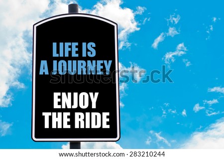 LIFE IS A JOURNEY ENJOY THE RIDE  motivational quote written on road sign isolated over clear blue sky background with available copy space. Concept  image