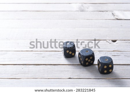 three dices with one dot on aged wooden background