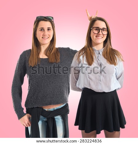 Girl teasing her sister over colorful background