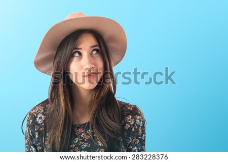 Cute woman thinking over colorful background